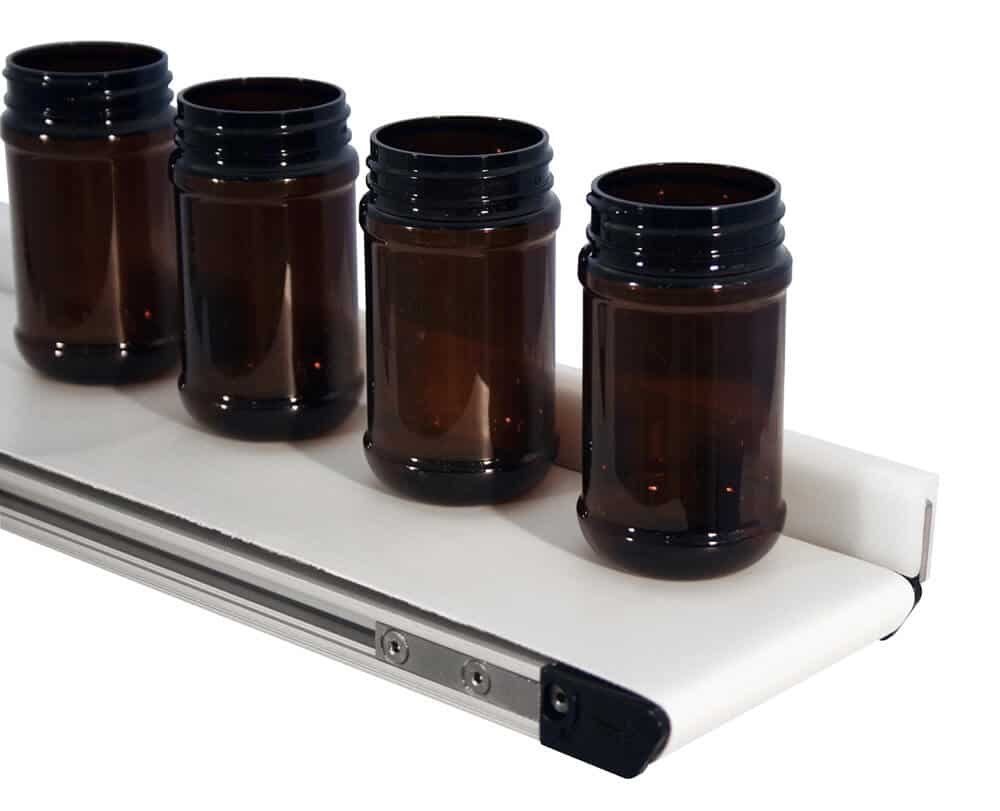 Empty bottles transported on a Dorner mini conveyor for nutraceutical products.