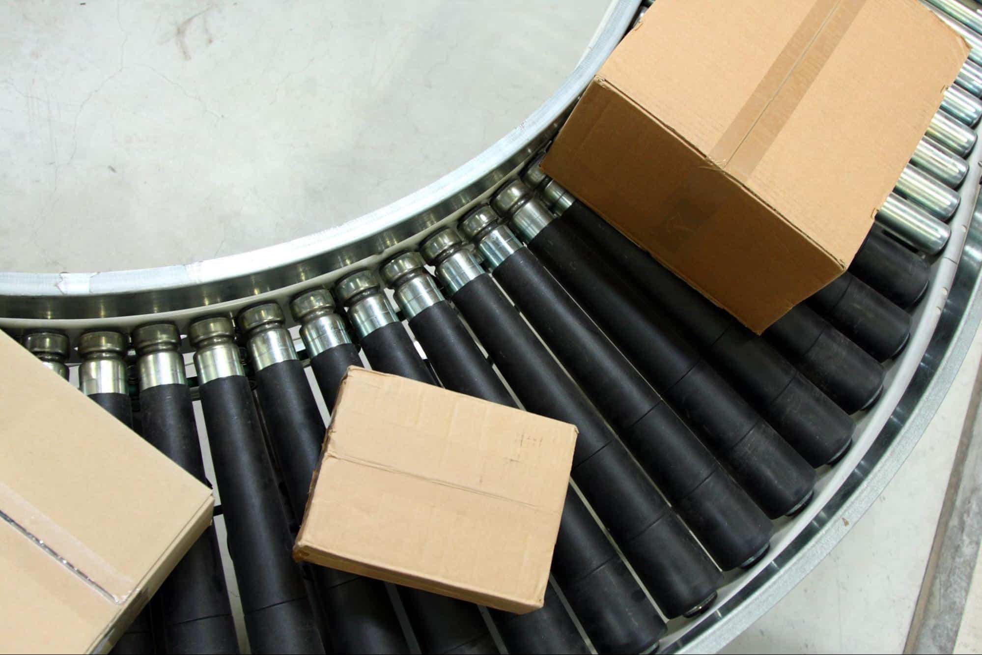 A gravity roller conveyor transporting packages around a curve, depicted from above.